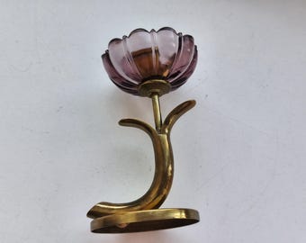 May include: A vintage decorative piece featuring a purple glass flower-shaped bowl atop a brass stem and base. The brass stem has a curved, organic design. The flower bowl is a translucent purple color.