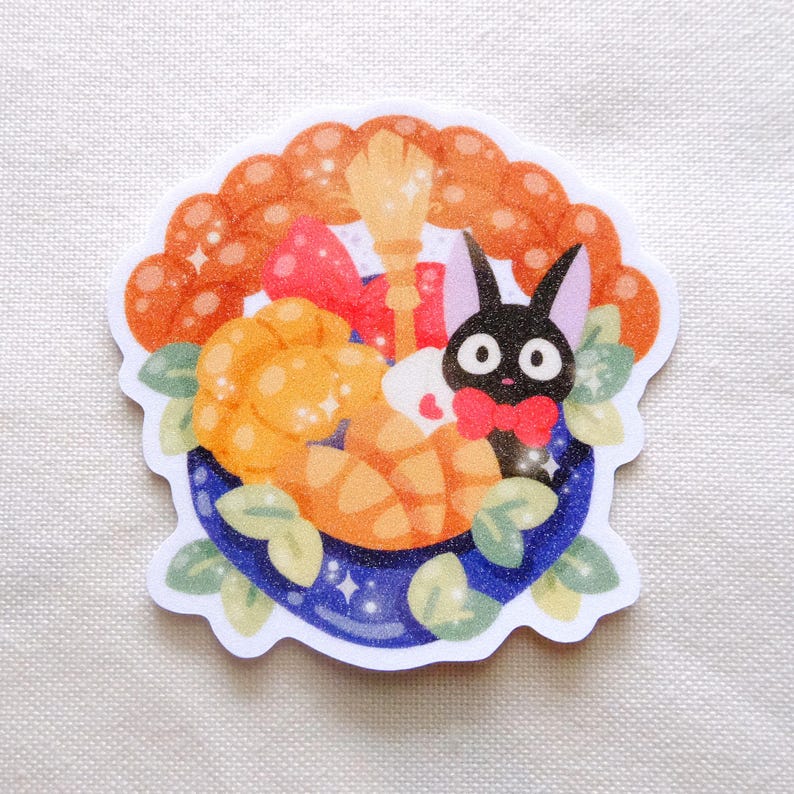 Pode incluir: Um autocolante com um gato preto de desenho animado com uma gravata borboleta vermelha, rodeado por uma tigela azul cheia de doces laranja, uma vassoura e um la&ccedil;o vermelho. O autocolante tem uma borda ondulada laranja com brilhos e folhas verdes.