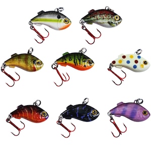 May include: Assortment of eight small fishing lures with different color patterns and designs. The lures are shaped like fish and have a treble hook.