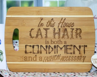 Striped Bamboo Cutting Board engraved with "In this house Cat Hair is both a Condiment and a Fashion Accessory"