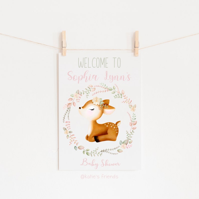 Pu&ograve; includere: Un cartello di benvenuto al Baby Shower di Sophia Lynn con un tenero cerbiatto in una ghirlanda di fiori. Il cartello &egrave; stampato su cartoncino bianco e ha una combinazione di colori rosa e verde.