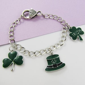 May include: A silver charm bracelet with green shamrock charms and a green leprechaun hat charm. One of the shamrock charms has the word "IRISH" on it.