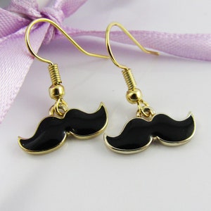 May include: A pair of gold-tone earrings with black enamel mustache charms.