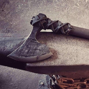 Hand-forged Fantasy Conan one-handed axe made of carbon steel with curved shaft and leather cross-wrap on the head