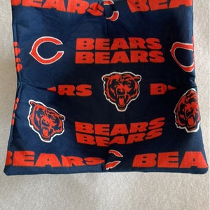 May include: Navy blue fabric item with repeating orange text and logos. The text reads "BEARS" and the Chicago Bears logo is visible. The item is rectangular and appears to be a small pillow or fabric pouch.