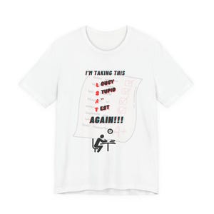 May include: A white short-sleeved t-shirt featuring a graphic of a test paper with the text I'M TAKING THIS LOUSY STUPID LSAT TEST AGAIN!!! in red and black. Below the paper is a black icon of a person sitting at a desk with a clock.