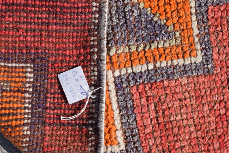 K&ouml;nnte beinhalten: Nahaufnahme eines bunten gewebten Teppichs mit einem Etikett mit der Aufschrift "6511 8" x 30" 27" x 10" 04"