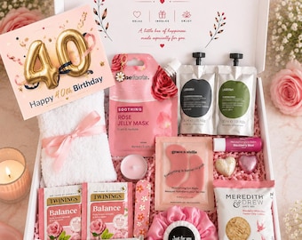 May include: A gift box containing a 40th birthday card, a white towel with a pink ribbon, a rose jelly mask, two skincare pouches, a lip balm, eye masks, two Twinings tea bags, a nail file, a pink scrunchie, a Galaxy chocolate bar, and cookies.