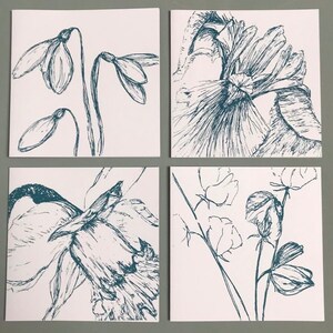 May include: Set of four greeting cards featuring hand-drawn illustrations of flowers in a blue ink. The cards feature a snowdrop, a daffodil, a sweet pea, and a large flower with a ruffled center.