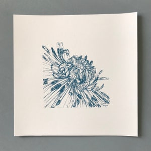 以下が含まれることがあります： 白い背景に、青いインクで描かれた、様式化された菊の花の図です。