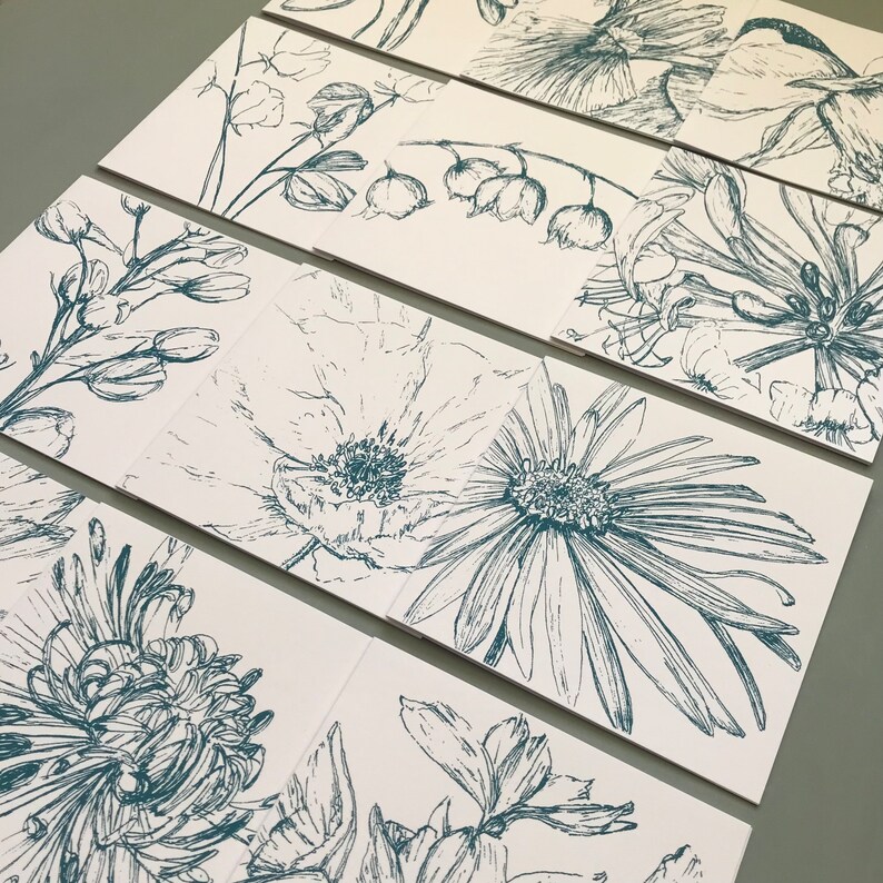 May include: Set of eight cards featuring hand-drawn illustrations of various flowers in a teal blue color. The cards are printed on white paper and have a subtle texture.