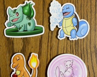 May include: Four colourful stickers featuring cartoon characters. One is a green creature with a bulb on its back, another is a blue turtle-like character, an orange creature with a flame tail, and a pink creature.