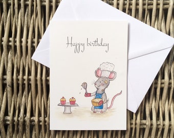 Puede incluir: Una tarjeta de felicitación blanca con el texto Happy birthday en letra negra. La ilustración muestra un ratón gris con un gorro de chef blanco, un delantal azul y guantes de cocina rojos, sosteniendo un batidor y un bol junto a dos cupcakes.