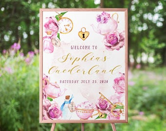Op de afbeelding: Een ingelijst bord met een roségouden rand, met aquarel illustraties van theekopjes, theepotten, rozen en een zakhorloge. Het bord leest "Welcome to Sophia's Onerderland" met de datum "Saturday July 25, 2020".