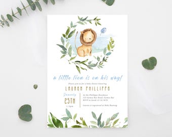 May include: A baby shower invitation featuring a watercolor illustration of a lion cub within a green foliage wreath. The text "a little lion is on his way!" is written in blue script, with event details below.