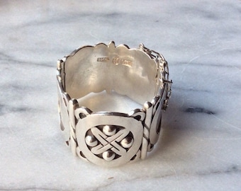 May include: A silver bracelet featuring a Celtic knot design and a clasp. The bracelet is hallmarked with "925" and "STERLING".