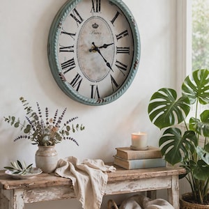 May include: A wall-mounted clock with a distressed light blue frame and a round face featuring black Roman numerals. The center of the clock face displays the word Paris and a small crown icon. The clock has black hands and a top hanging loop.