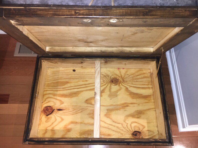 May include: Open wooden storage box with a hinged lid. The interior is made of plywood and has a divider in the middle.