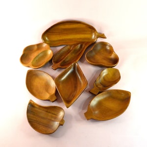 May include: Set of eight wooden serving dishes in various shapes and sizes. The dishes are made of natural wood and have a warm brown colour.
