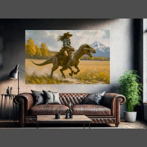 May include: A large canvas print depicts a woman riding a dinosaur through a field. The artwork features a mountain range in the background, with yellow trees and a blue sky. The woman wears a cowboy hat and denim shirt.