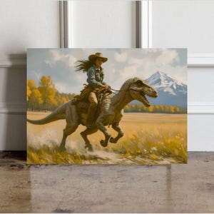 May include: A square canvas print depicts a woman in a cowboy hat riding a dinosaur across a field. The artwork features a mountain range in the background, with yellow and green foliage. The woman wears a denim jacket and brown pants.