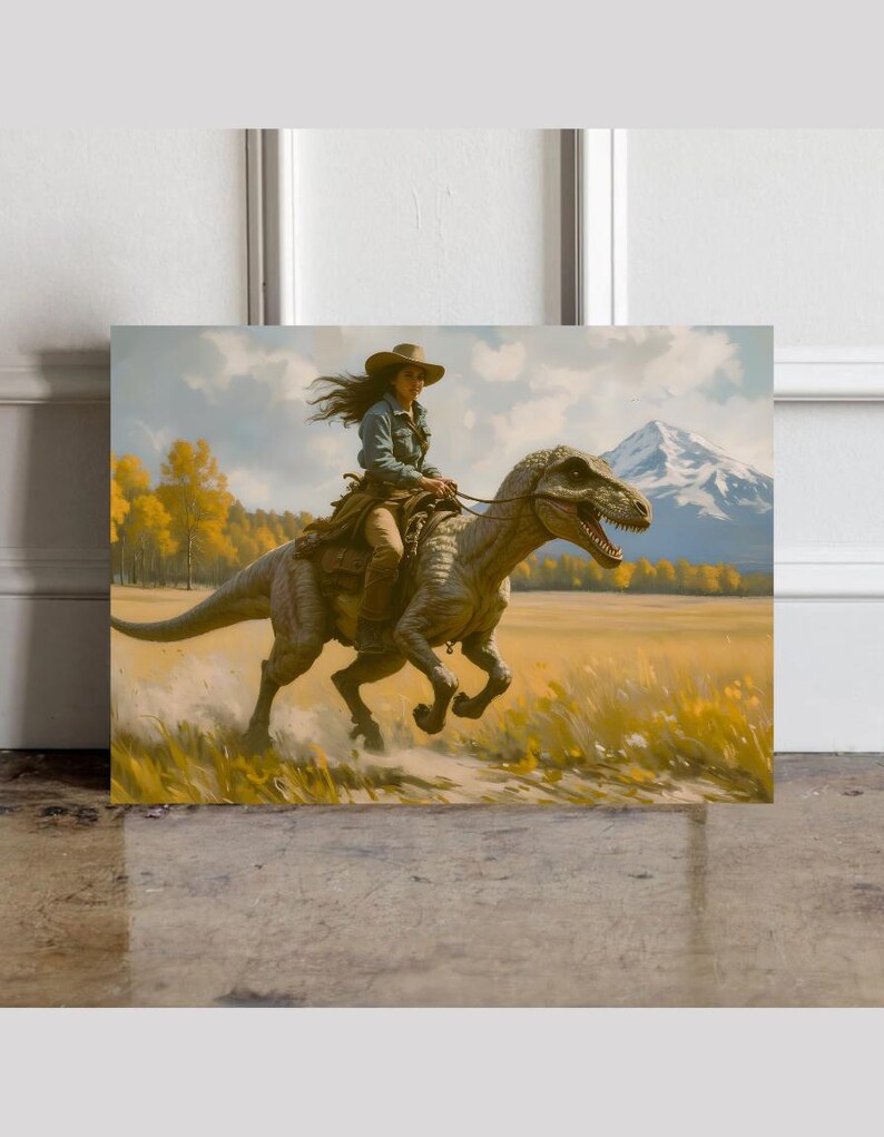 May include: A square canvas print depicts a woman in a cowboy hat riding a dinosaur across a field. The artwork features a mountain range in the background, with yellow and green foliage. The woman wears a denim jacket and brown pants.