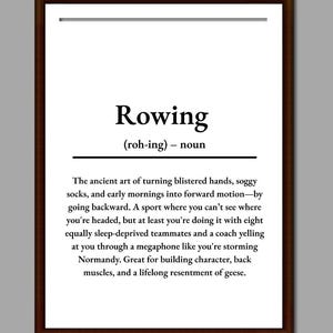 Puede incluir: Impresión enmarcada con la definición de "Rowing" en texto negro sobre fondo blanco. La definición describe los desafíos y aspectos humorísticos del deporte. El marco es de color marrón oscuro.