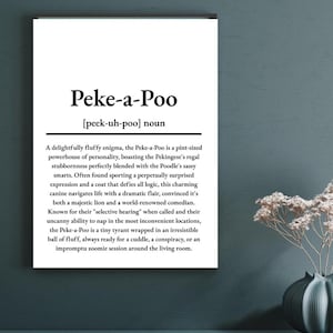 May include: A framed print with the text "Peke-a-Poo [peek-uh-poo] noun." The description below details the Peke-a-Poo's personality, a mix of Pekingese and Poodle traits. The print is displayed on a shelf with a vase of flowers.