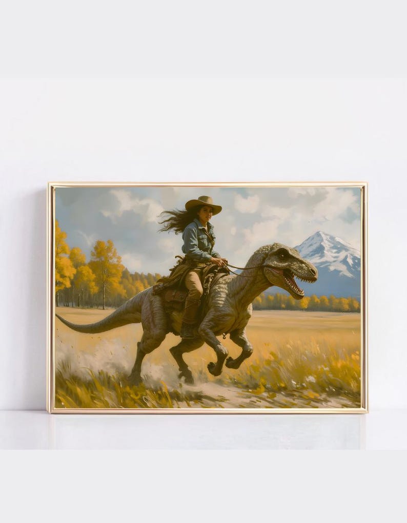 May include: Framed artwork depicting a person riding a dinosaur through a field. The person wears a cowboy hat and denim shirt. The dinosaur is gray and brown. The background features a mountain, trees, and a yellow field.