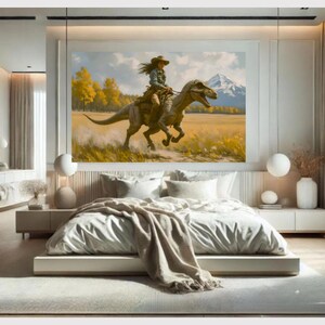 May include: A large framed painting depicts a person riding a dinosaur through a field. The person wears a hat and western attire. The background shows a mountain range and yellow trees. The painting is displayed above a bed with white bedding.