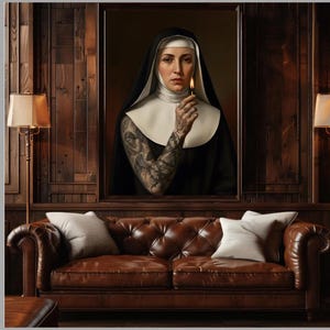 May include: A framed portrait of a nun holding a lit match, with intricate tattoos on her arm. The portrait is above a brown leather tufted sofa with two white pillows. The room has dark wood paneling and a lamp.
