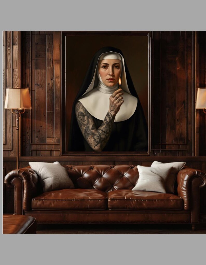 May include: A framed portrait of a nun holding a lit match, with intricate tattoos on her arm. The portrait is above a brown leather tufted sofa with two white pillows. The room has dark wood paneling and a lamp.