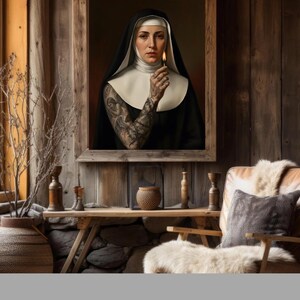 May include: A framed portrait of a nun holding a lit match, set against a rustic wooden backdrop. The nun wears a traditional black habit with a white collar and veil. Her arm is covered in intricate tattoos. The room features a wooden table with decorative items.