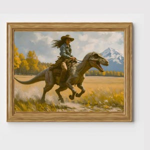 May include: A framed art print depicts a person riding a dinosaur through a field. The person wears a cowboy hat and denim jacket. The dinosaur is gray and tan, with a saddle. The background features a mountain, trees, and a blue sky.
