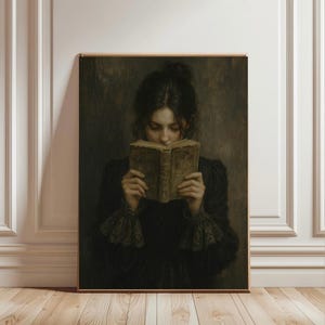 May include: A framed portrait of a person reading a book. The person is wearing a dark dress with lace cuffs. The book is old with yellowed pages. The background is a dark, muted color.