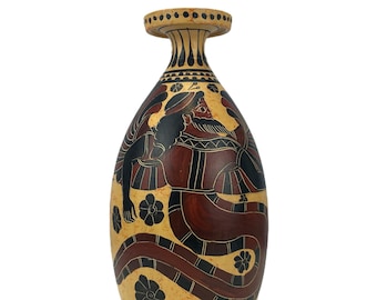 May include: A ceramic vase with a red, black and white design depicting a mythical creature. The vase has a rounded body and a narrow neck.