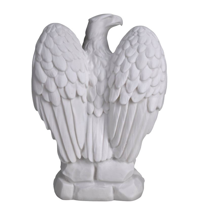 Op de afbeelding: Een witte adelaar sculptuur met uitgespreide vleugels, met gedetailleerde veermotieven. De sculptuur staat op een getextureerde basis. Het materiaal lijkt solide en ondoorzichtig, met de nadruk op de vorm en textuur van de vogel.