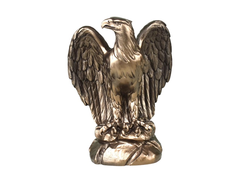 Pode incluir: Uma estatueta de &aacute;guia na cor bronze sobre uma base de rocha texturizada. A &aacute;guia &eacute; representada com as asas parcialmente abertas, a cabe&ccedil;a virada para o lado e texturas detalhadas de penas no corpo, asas e cauda, com acabamento em tom met&aacute;lico.