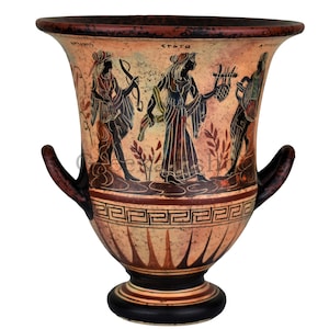 May include: A black and red Greek style ceramic vase with two handles. The vase is decorated with a black and white painted scene of three figures playing music. The vase has a geometric pattern around the middle and a black base.