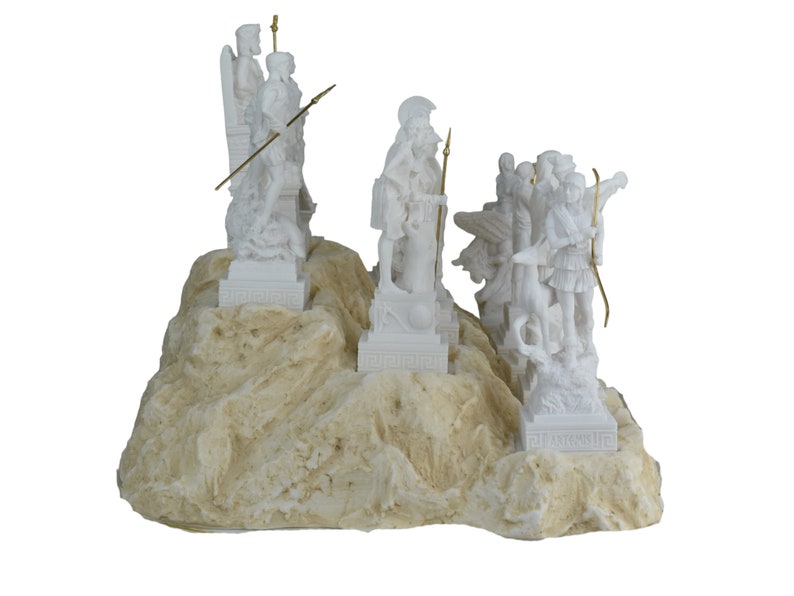 May include: White alabaster sculpture of Greek gods and goddesses standing on a rocky base. The sculpture features figures of Zeus, Athena, Artemis, Apollo, and Hermes.