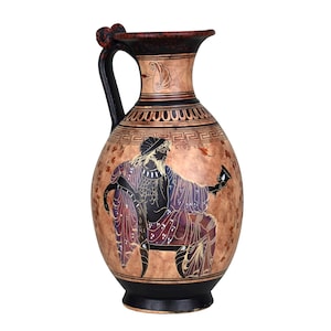 Könnte beinhalten: Eine braune Keramikvase mit einem schwarzen Henkel und einem schwarzen Sockel. Die Vase ist mit einem Schwarz-Weiß-Bild einer Figur mit einer Tasse verziert. Die Vase hat ein geometrisches Muster um die Oberseite.
