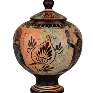 May include: A hand-painted ceramic vase with a lid, featuring a stylized floral design and a scene of a woman holding a mirror. The vase is decorated in black, red, and white on a beige background. The vase has a round body and a tall, slender base.