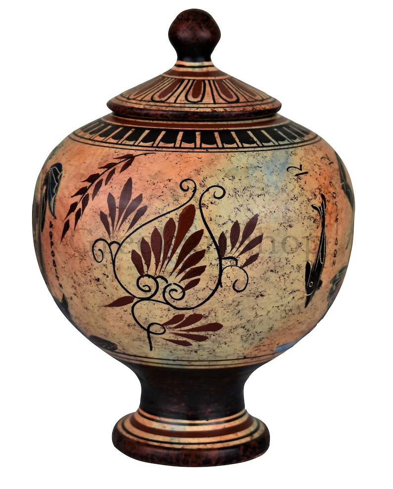 May include: A hand-painted ceramic vase with a lid, featuring a floral design in shades of brown and orange on a cream background. The vase has a round body and a pedestal base.