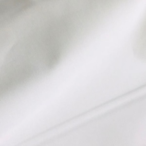 May include: White fabric with a smooth texture and a slight sheen. The fabric is folded in half, creating a crease down the center.