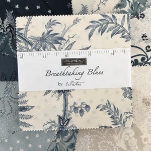 Peut inclure: Une pile de carr&eacute;s de tissu pr&eacute;sentant divers motifs floraux et botaniques bleus et cr&egrave;me. Une bande de papier blanc entoure le centre, imprim&eacute;e avec "moda FABRICS+SUPPLIES", "Breathtaking Blues" et "by 3 Sisters", avec une r&egrave;gle de 12,7 cm.