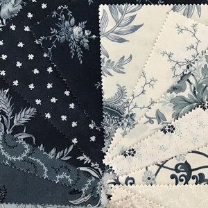 Peut inclure: Une collection d'&eacute;chantillons de tissu dispos&eacute;s en &eacute;ventail, pr&eacute;sentant divers motifs dans des tons bleu marine, gris ardoise et cr&egrave;me. Les designs incluent des motifs floraux, de petites feuilles et des illustrations botaniques aux bords dentel&eacute;s.