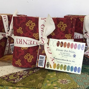 May include: A bundle of fabric fat quarters titled Flower Pot Prints by Kim Diehl for Henry Glass & Co. Inc. The set includes 20 pieces measuring 18 inches by 21 inches, featuring various floral and geometric patterns in red, green, and cream tones.
