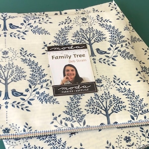 May include: Fabric bundles with a cream background and a blue tree and bird pattern. The fabric is labeled "Family Tree" by Deb Strain from Moda Fabrics & Supplies.