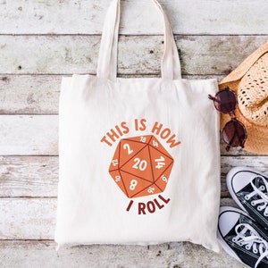 May include: White canvas tote bag with a red and white dice graphic and the text "This is how I roll".