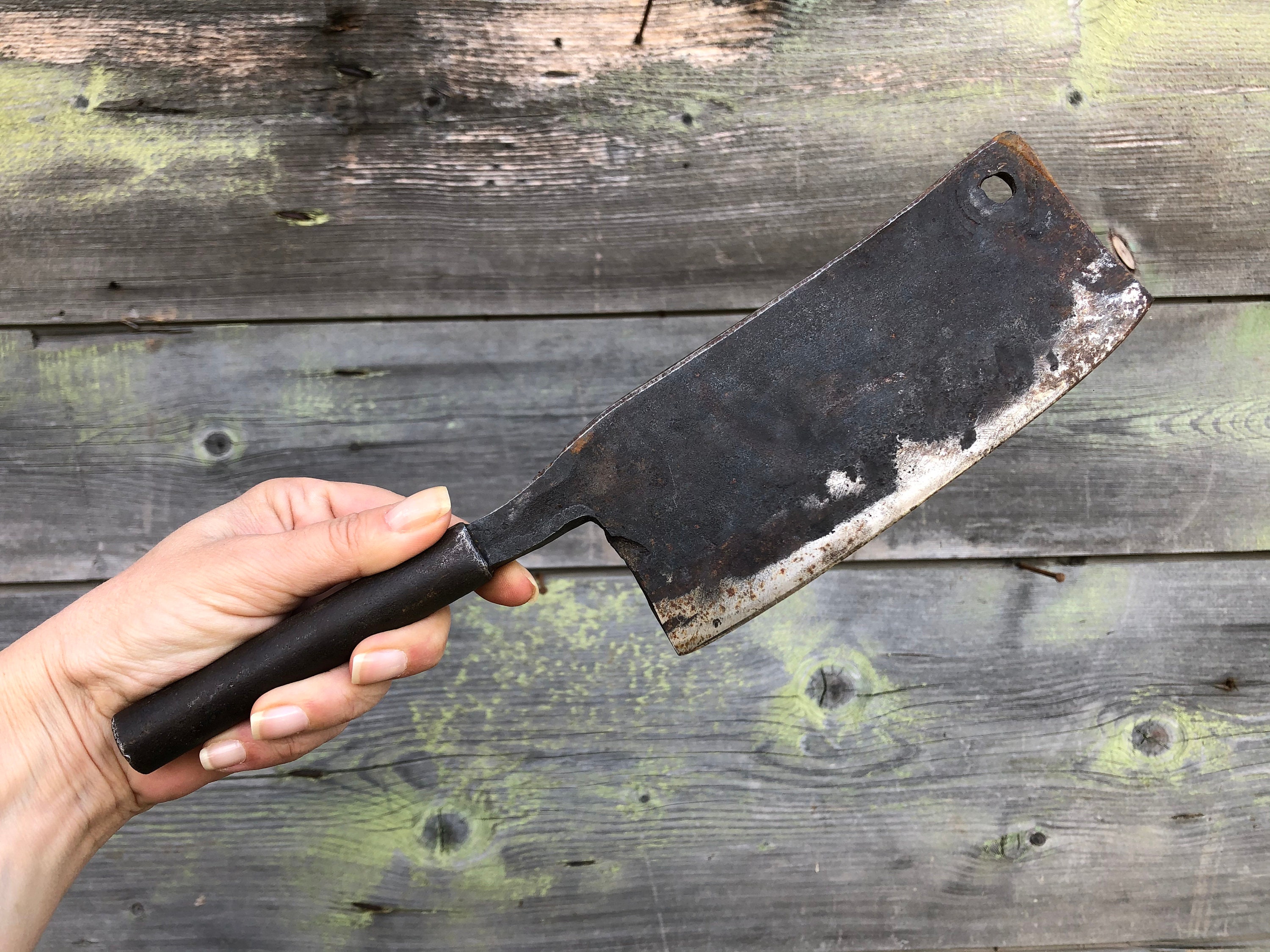 una linea continua di disegno a mano che tiene la mannaia da cucina della  carne, coltello da macellaio. affilato, utensile. concetto di attrezzatura.  mannaia usata per argomenti come cucina, cucina, chef. vettore